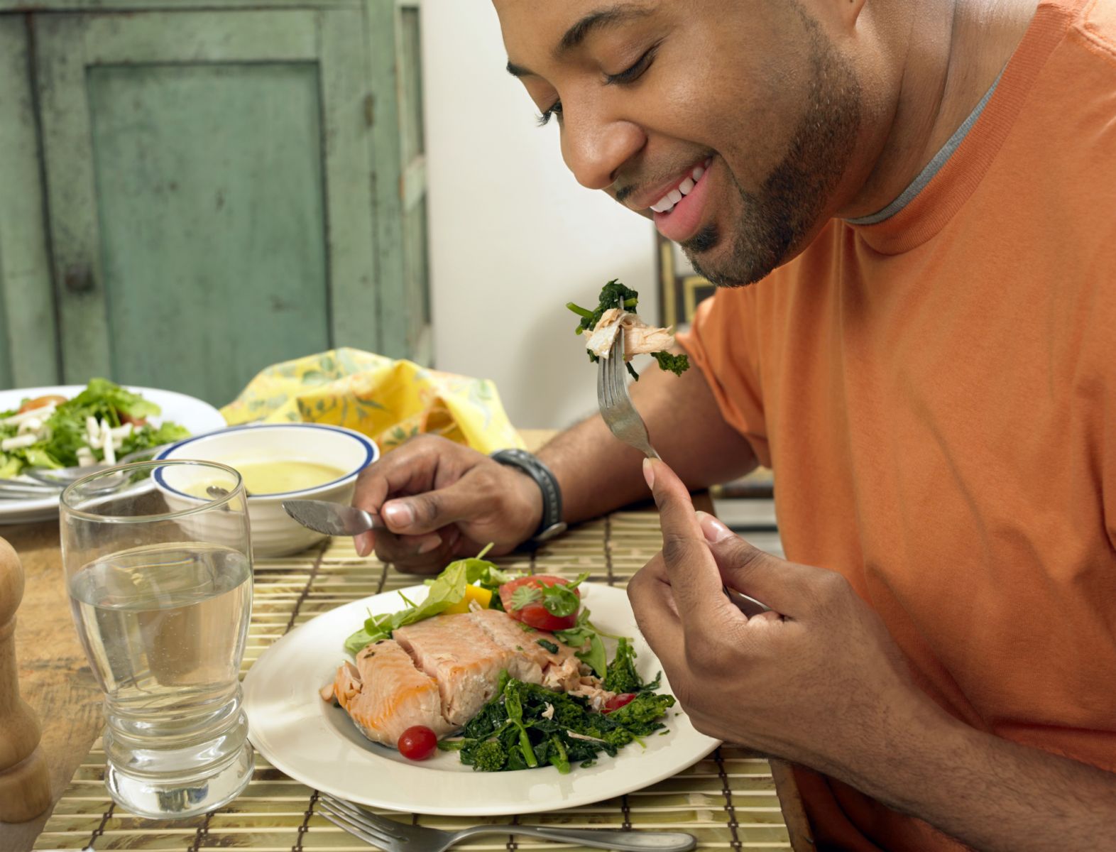 Uomo che mangia salmone , una buona fonte di cuore-protezione di omega-3 acidi grassi